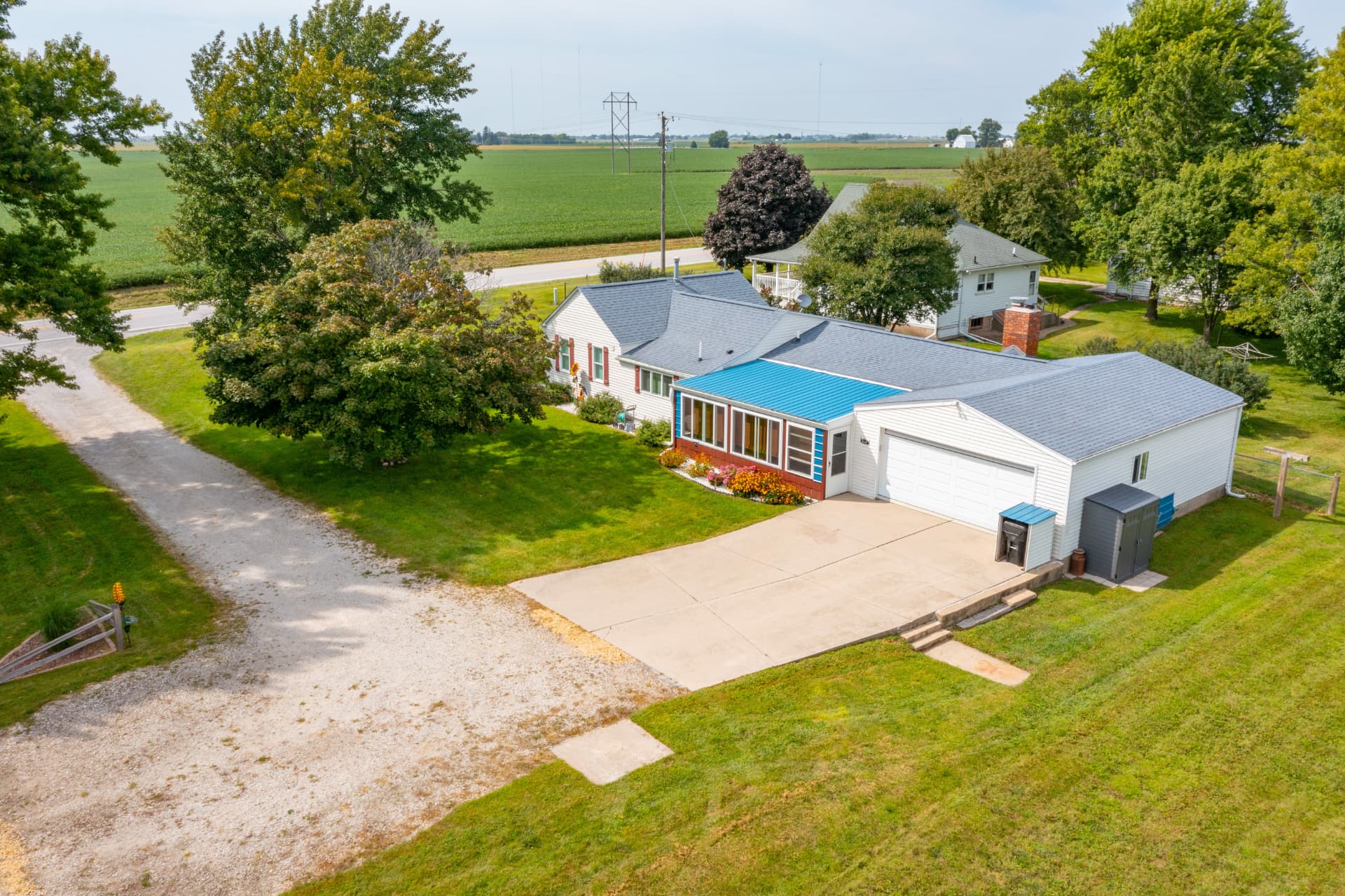 Aerial view of the home, sun porch and attached garage on the park-like acreage