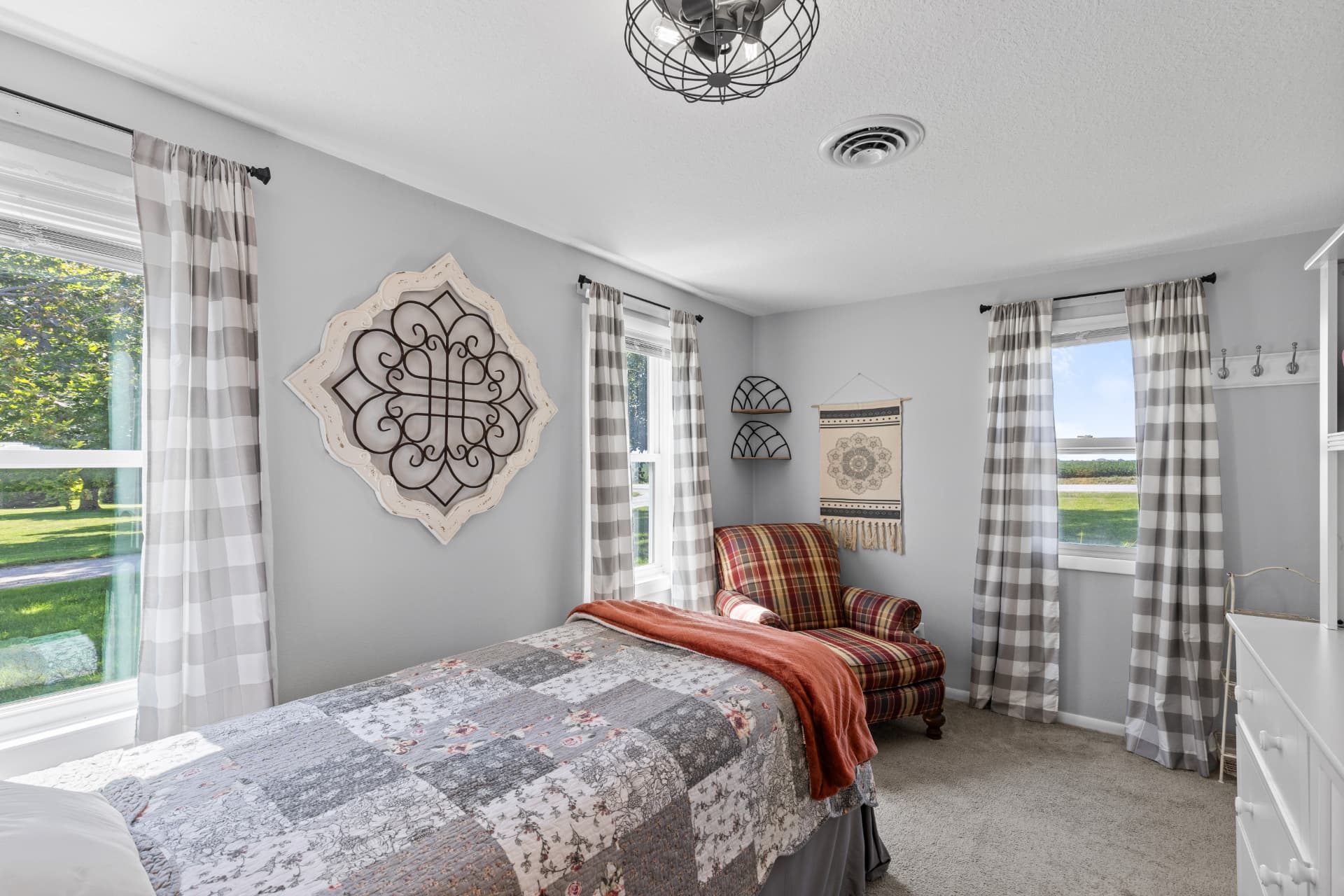 Bright corner bedroom with three windows and country views