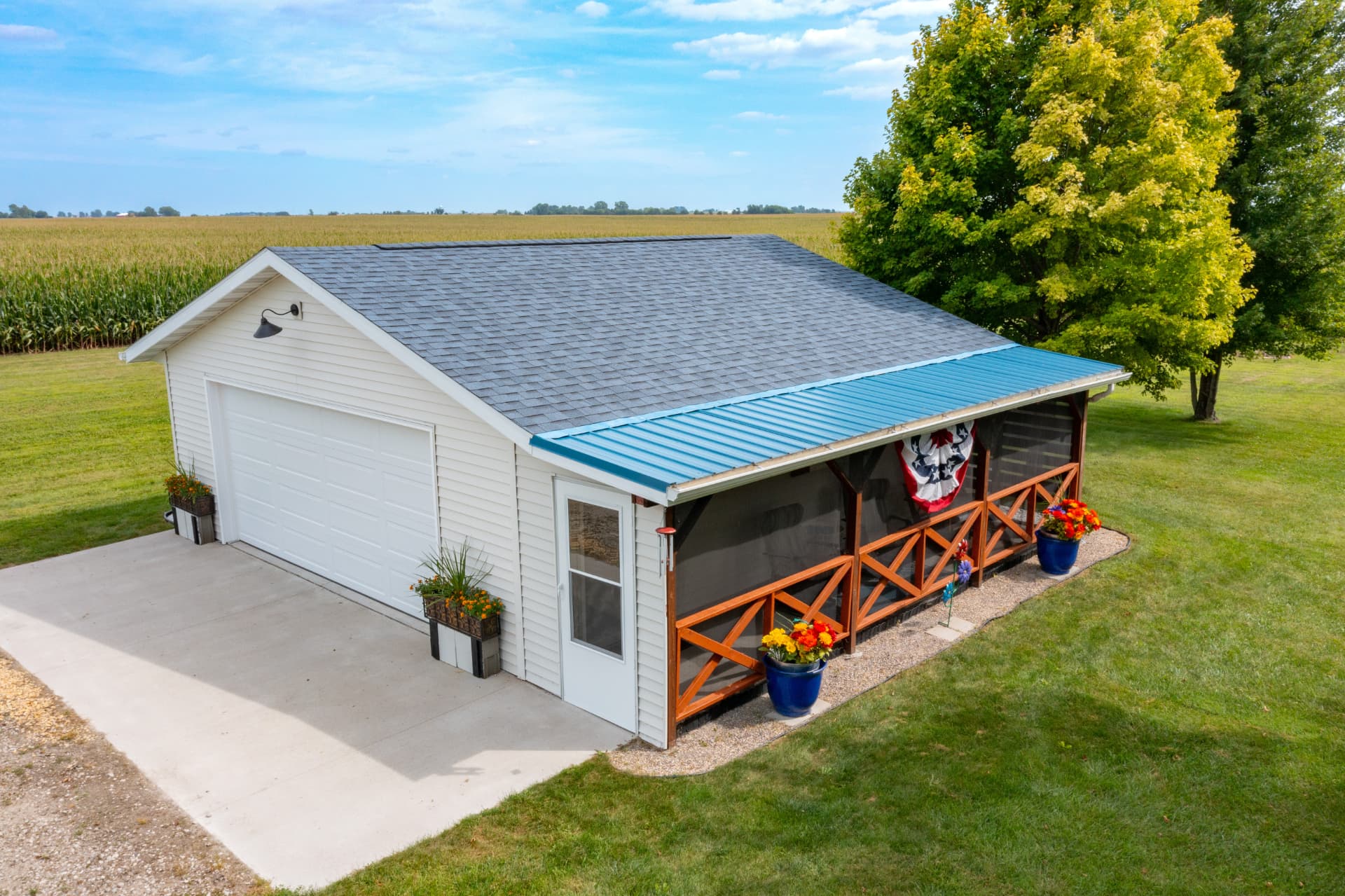 Detached garage screened-in porch with timber railing overlooking the field
