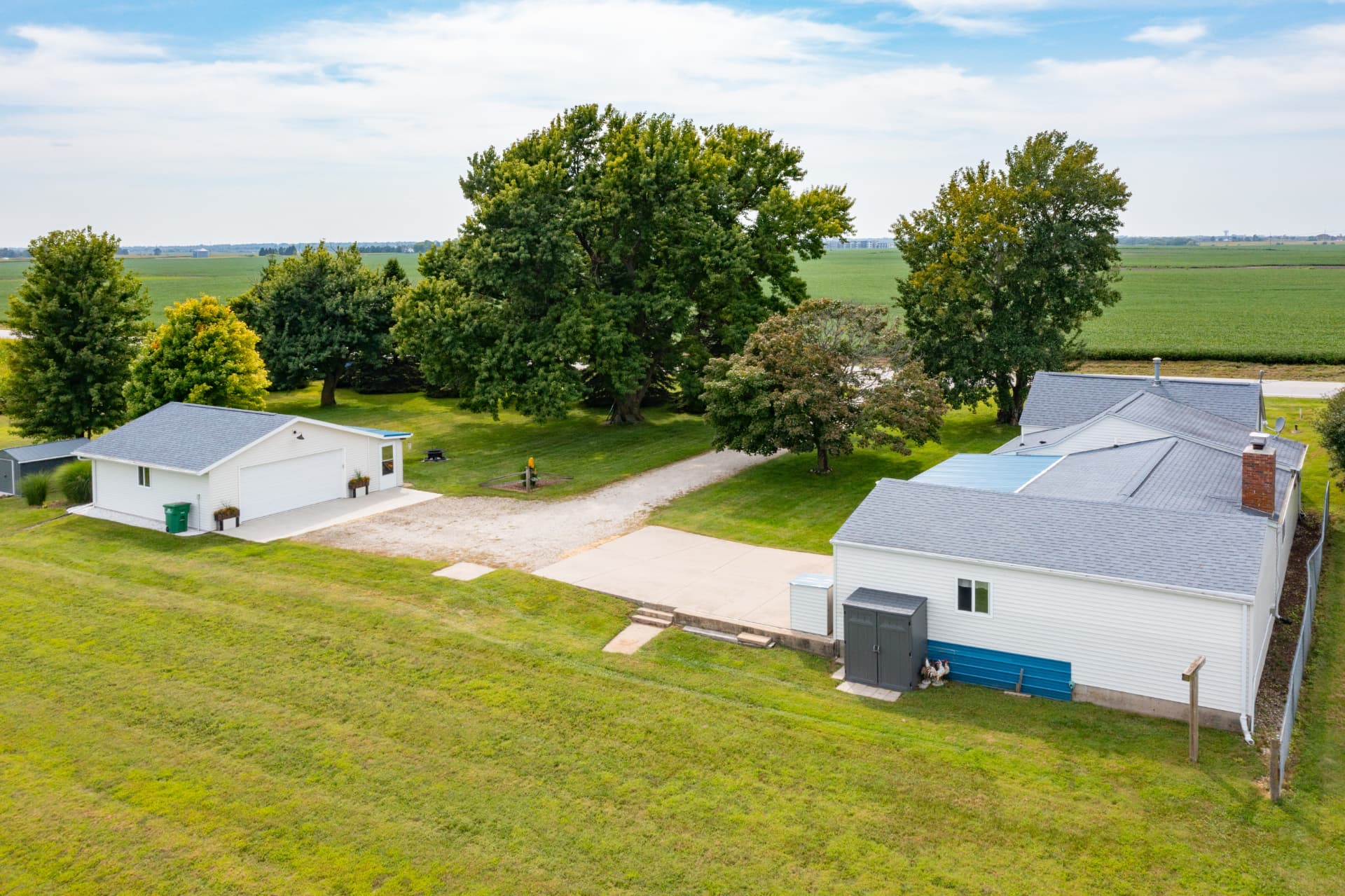 Aerial view of the yard between the home and the new detached garage with mature trees