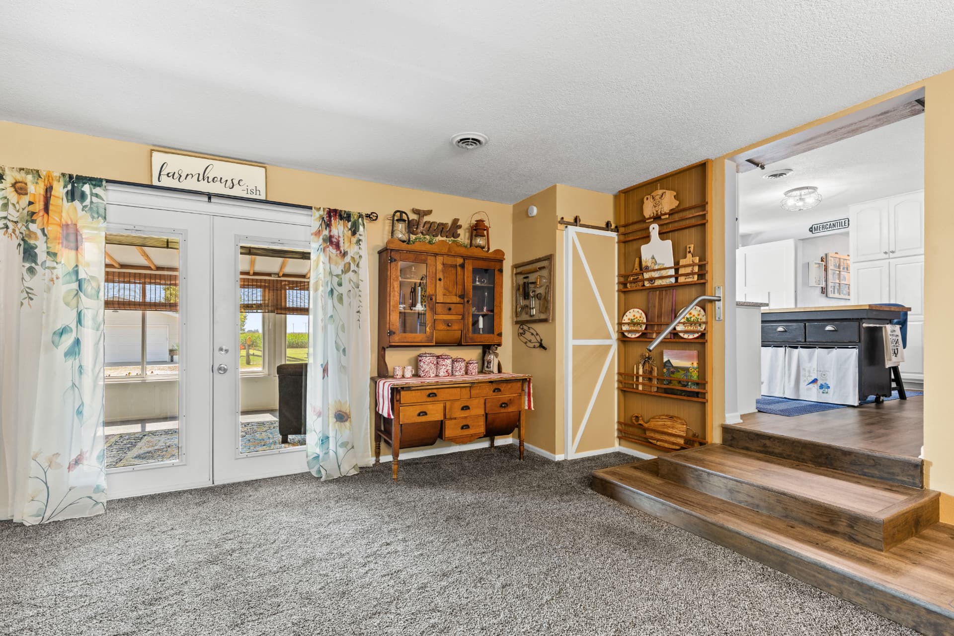 462 sq ft great room with French doors, barn door and steps up to the kitchen