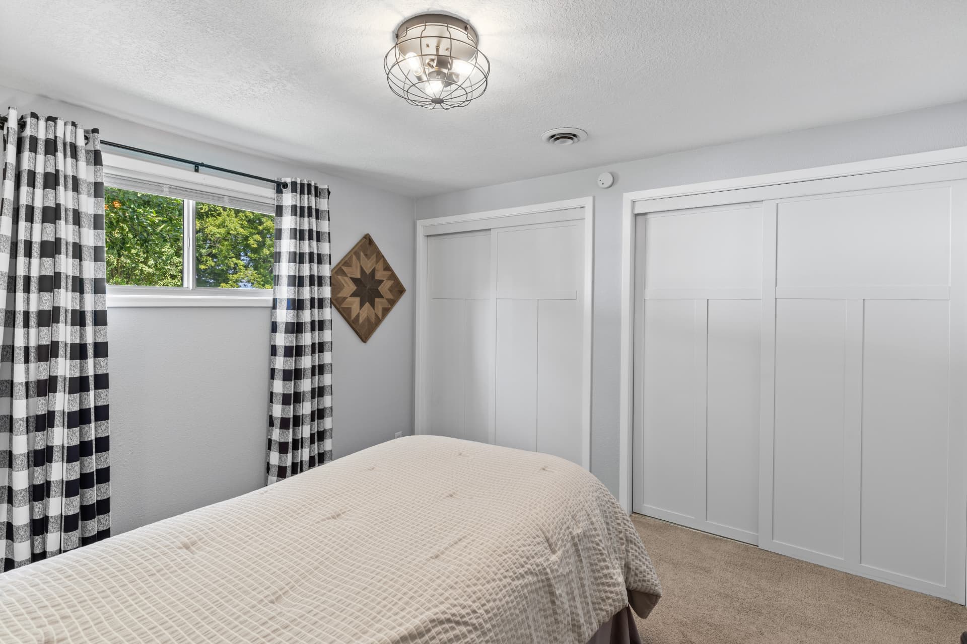 Bedroom with double closets and buffalo check curtains